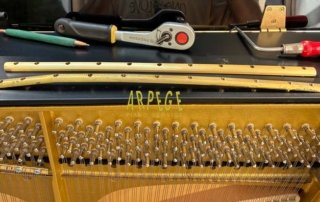 Remplacement par une barre neuve, de la barre de pression d'origine de ce piano Schimmel 119 Tradition, déformée suite à la casse de plusieurs vis.