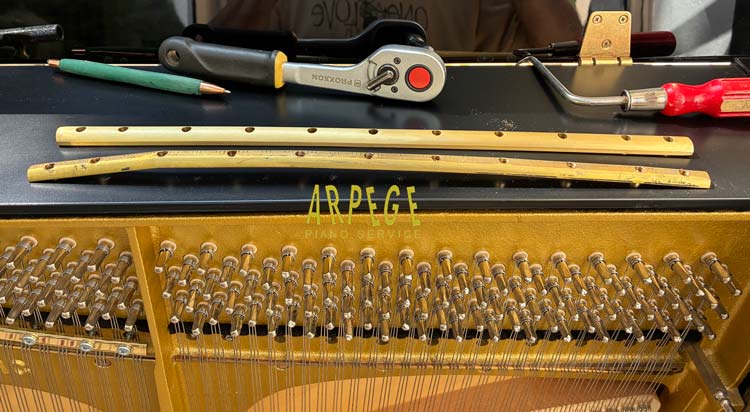 Remplacement par une barre neuve, de la barre de pression d'origine de ce piano Schimmel 119 Tradition, déformée suite à la casse de plusieurs vis.